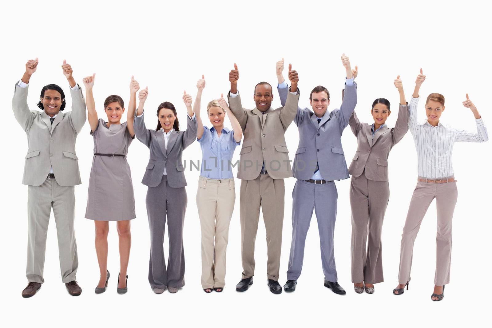 Business team raising their arms with the thumbs up against white background