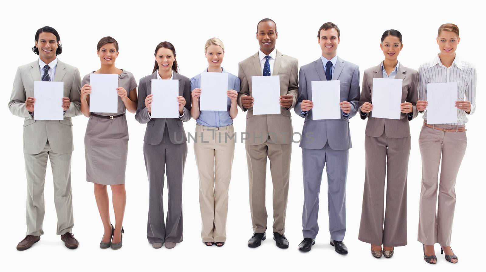Business people smiling while holding white support for letters against white background