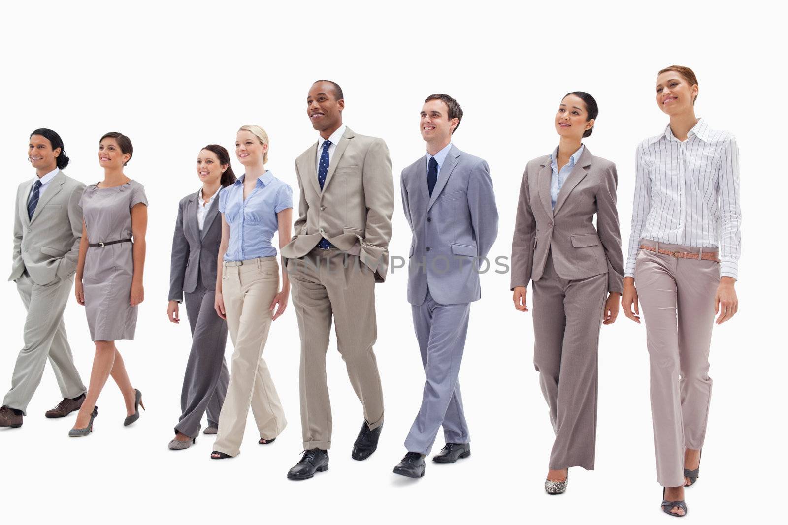 Smiling business team walking against white background