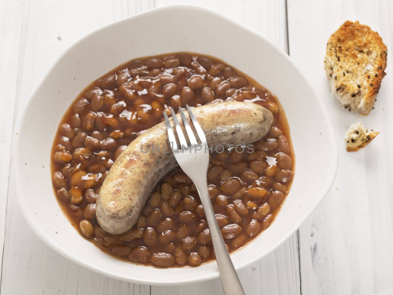 close up of  plate of baked beans and sausage