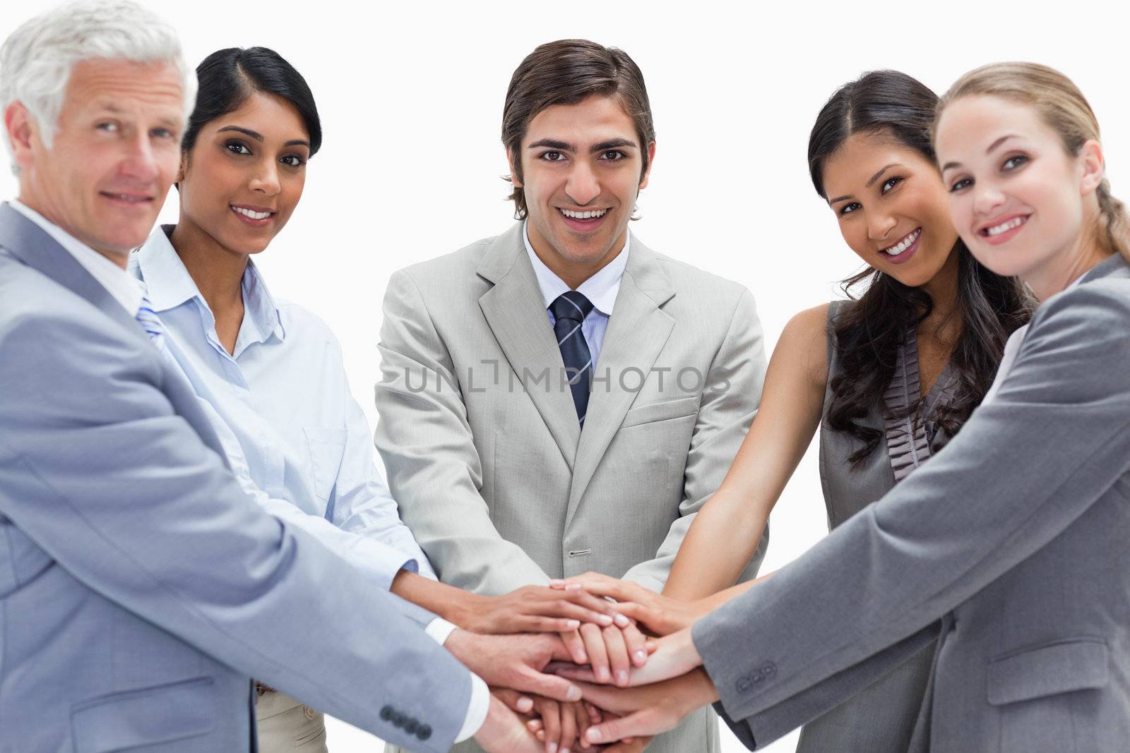 Close-up of people putting their hands on each others against white background
