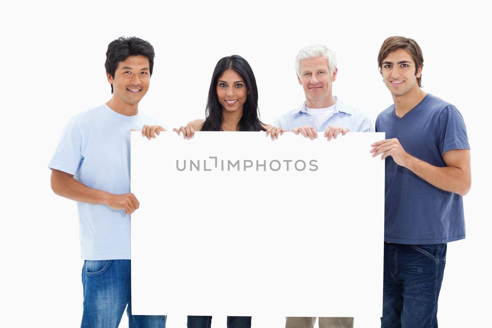 People in jeans holding a big sign  by Wavebreakmedia