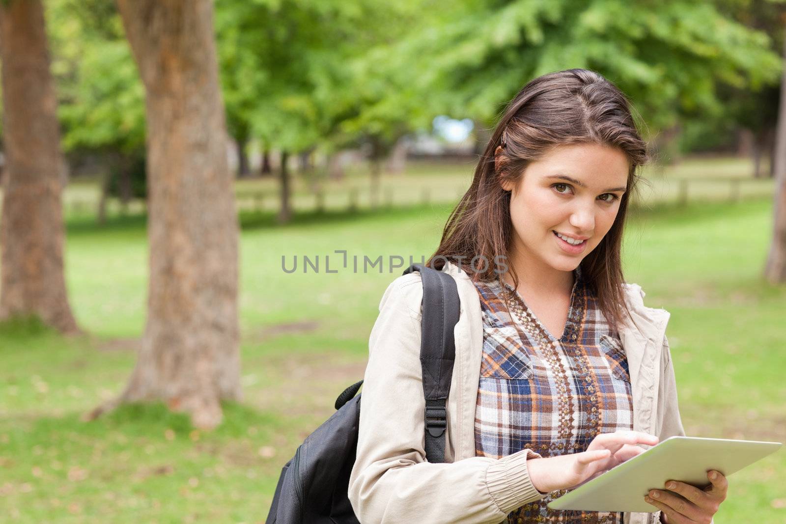 Portrait of a first-year female student using a touch pad in a park
