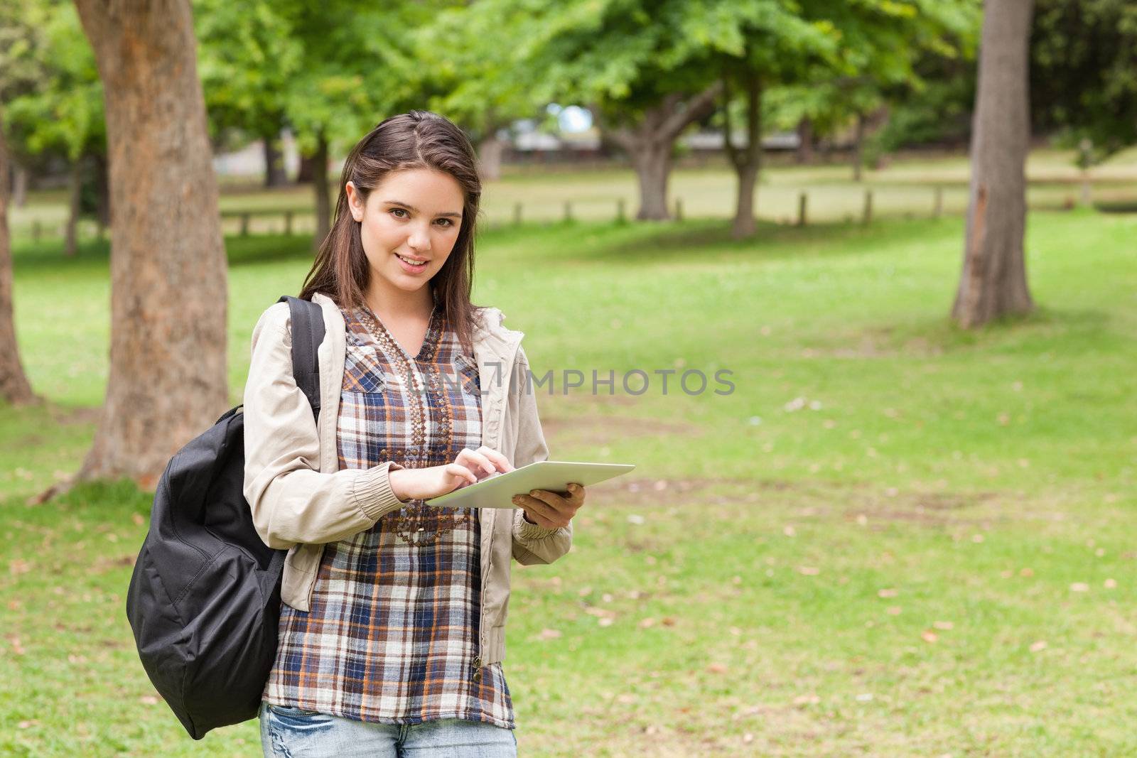 Young student using a tactile tablet in a park