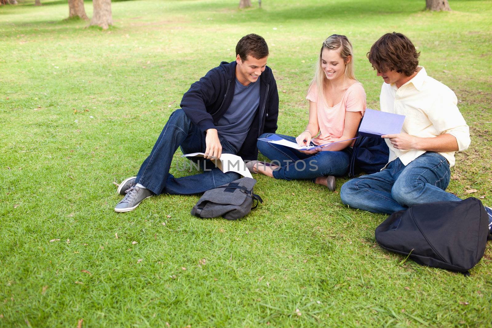 High angle-shot of three students in a park studying