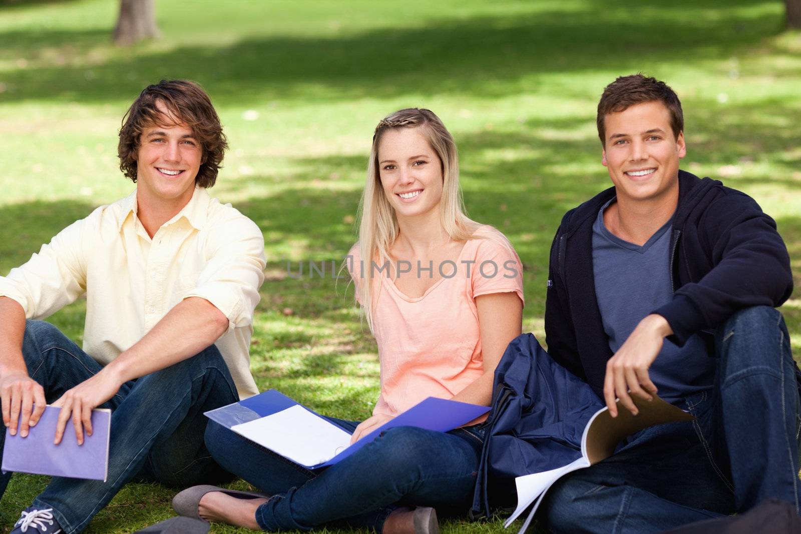 Portrait of three students in a park studying