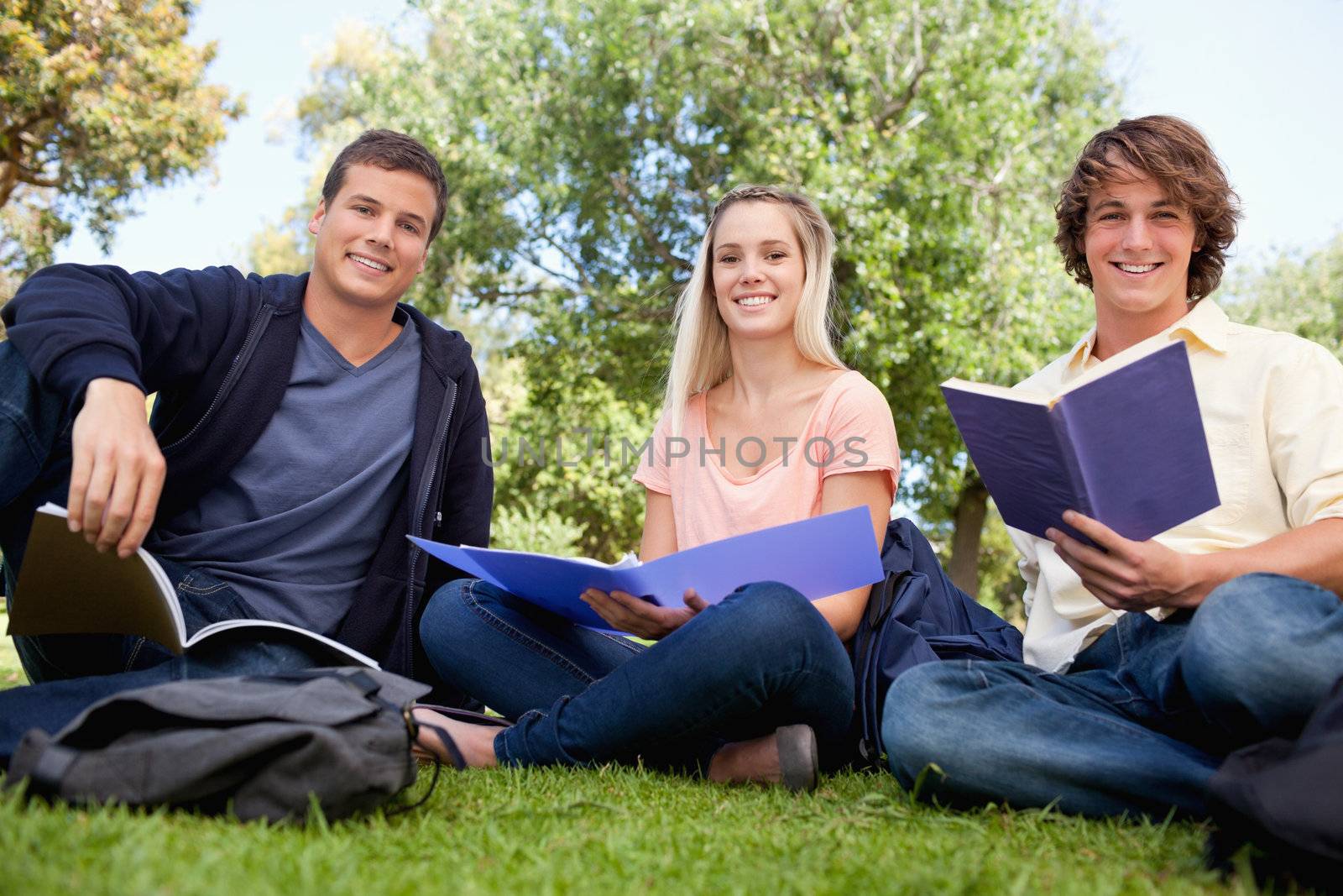 Low angle-shot of three smiling students working by Wavebreakmedia