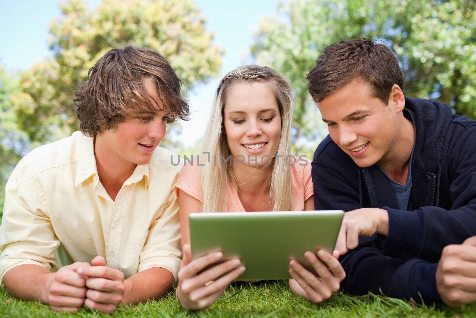 Three students using a touch pad by Wavebreakmedia