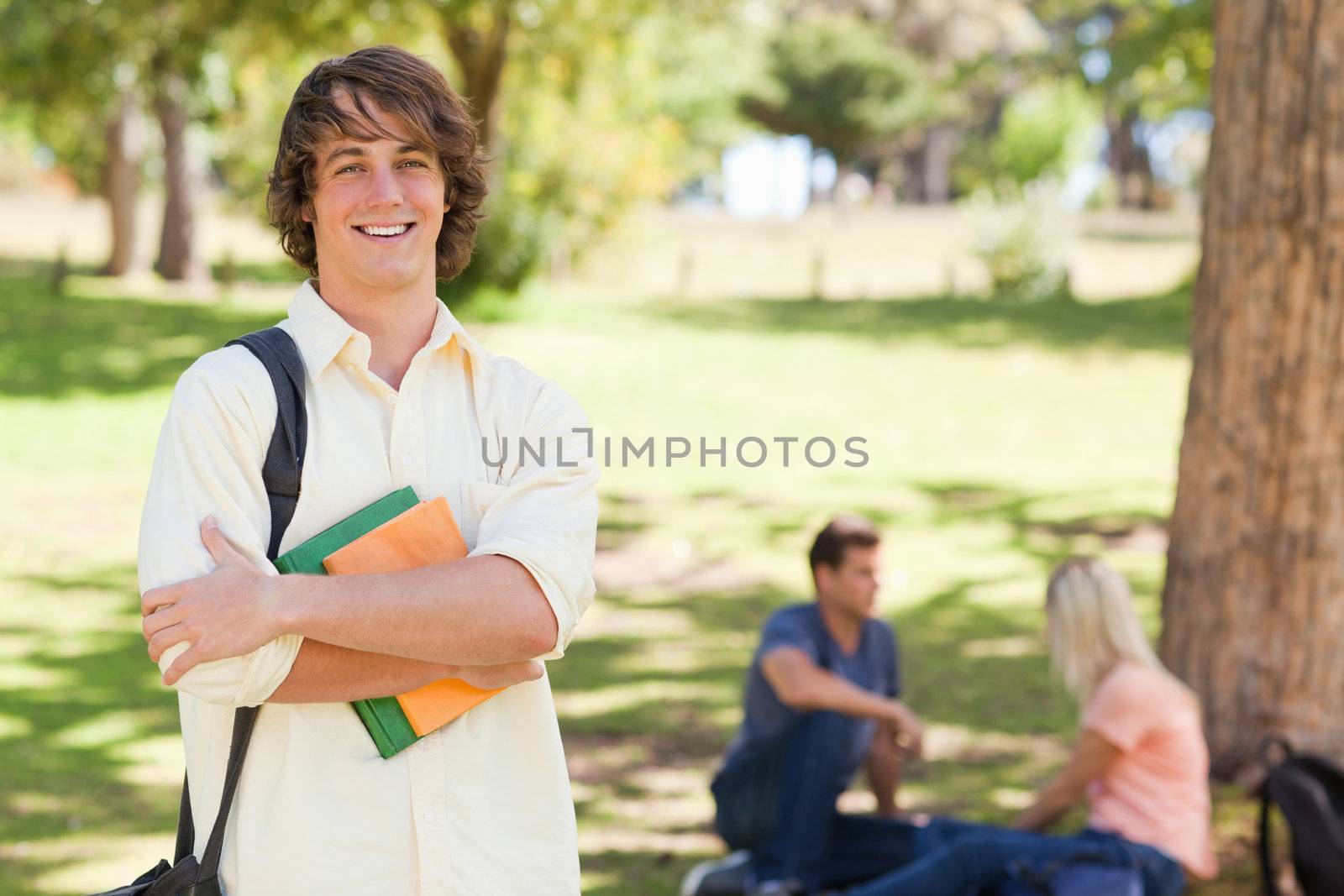 Young man posing with textbook by Wavebreakmedia