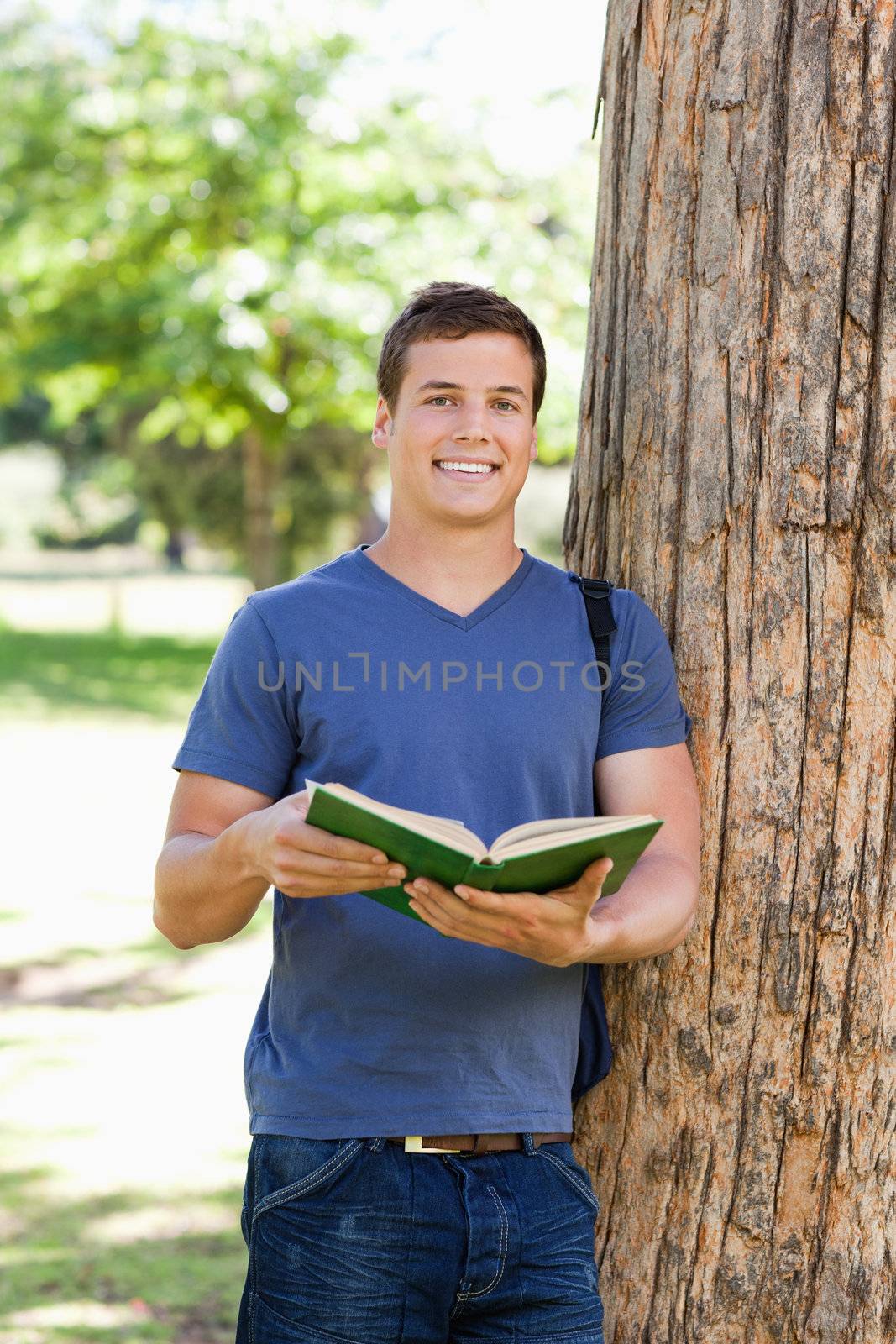 Portrait of a muscled young man holding a book by Wavebreakmedia