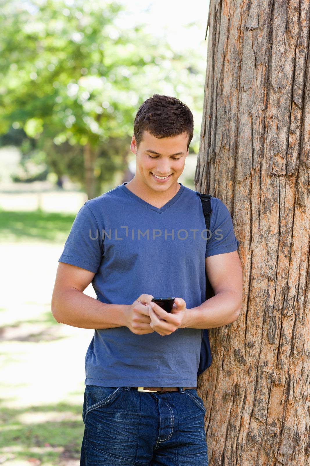 Muscled young man using a smartphone by Wavebreakmedia