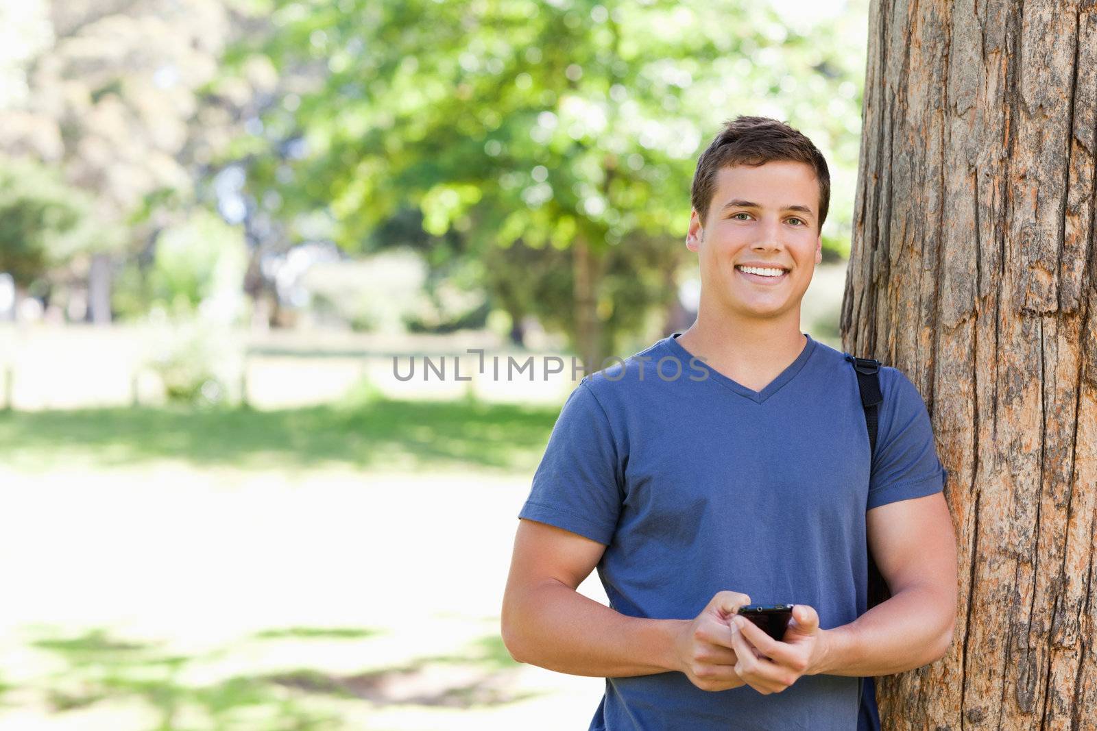 Portrait of a muscled young man with a smartphone by Wavebreakmedia