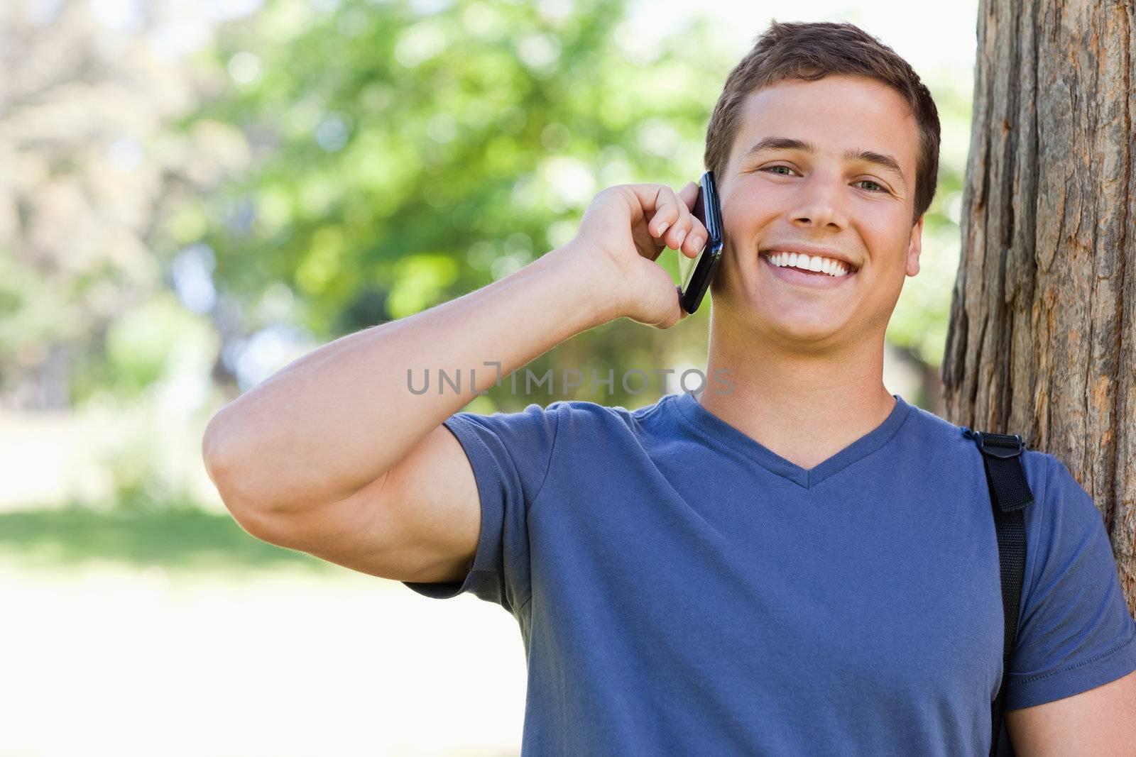 Close-up of a muscled young man on the phone by Wavebreakmedia