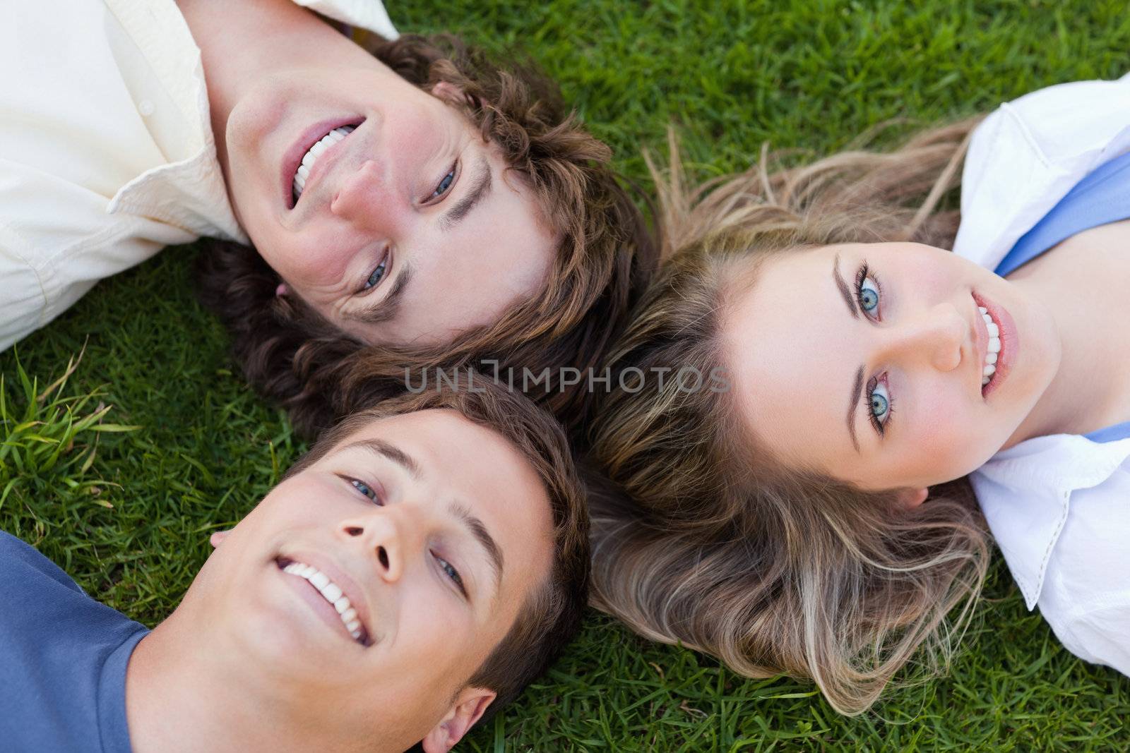 Close-up on three students lying together by Wavebreakmedia