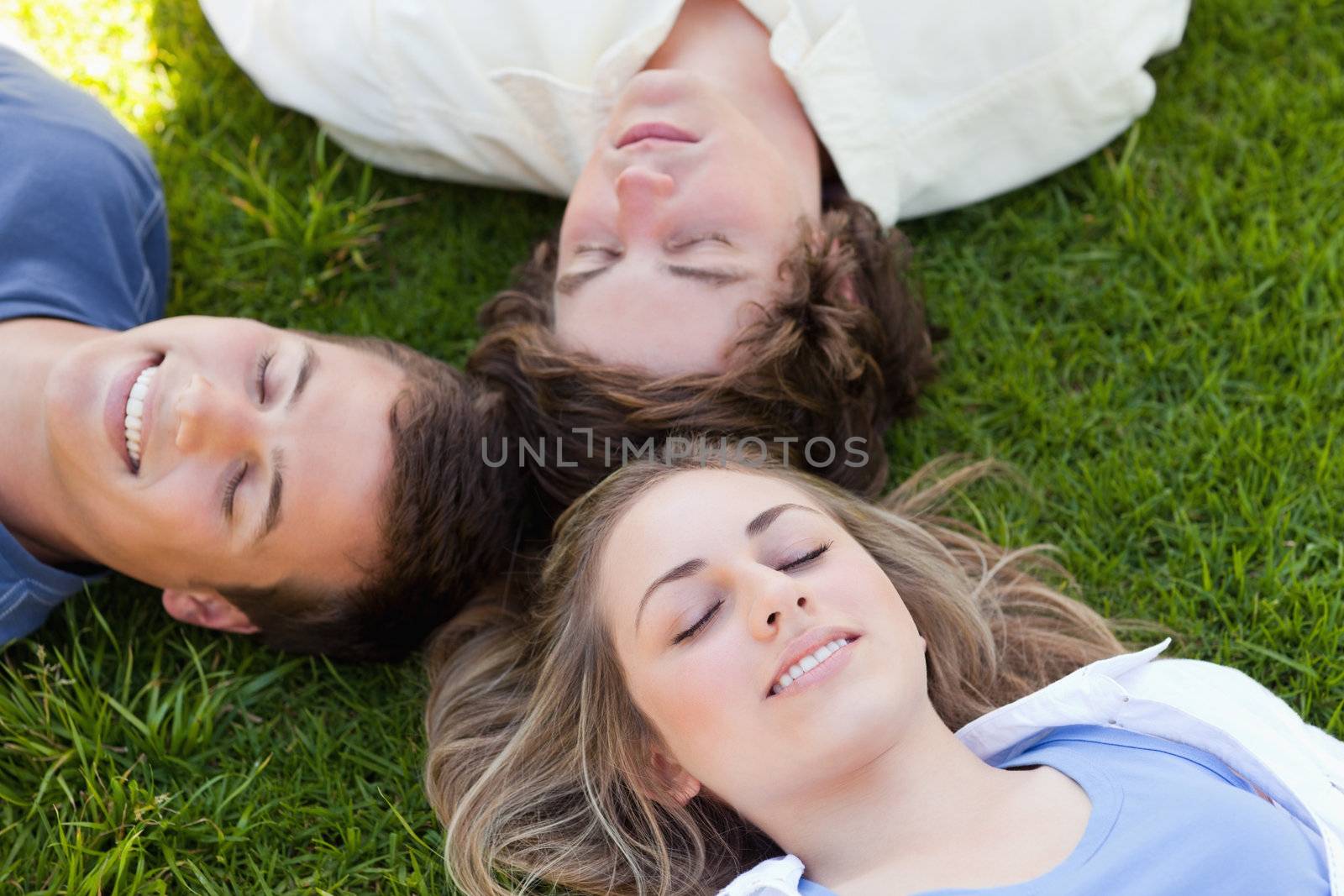 Three students resting together in the grass