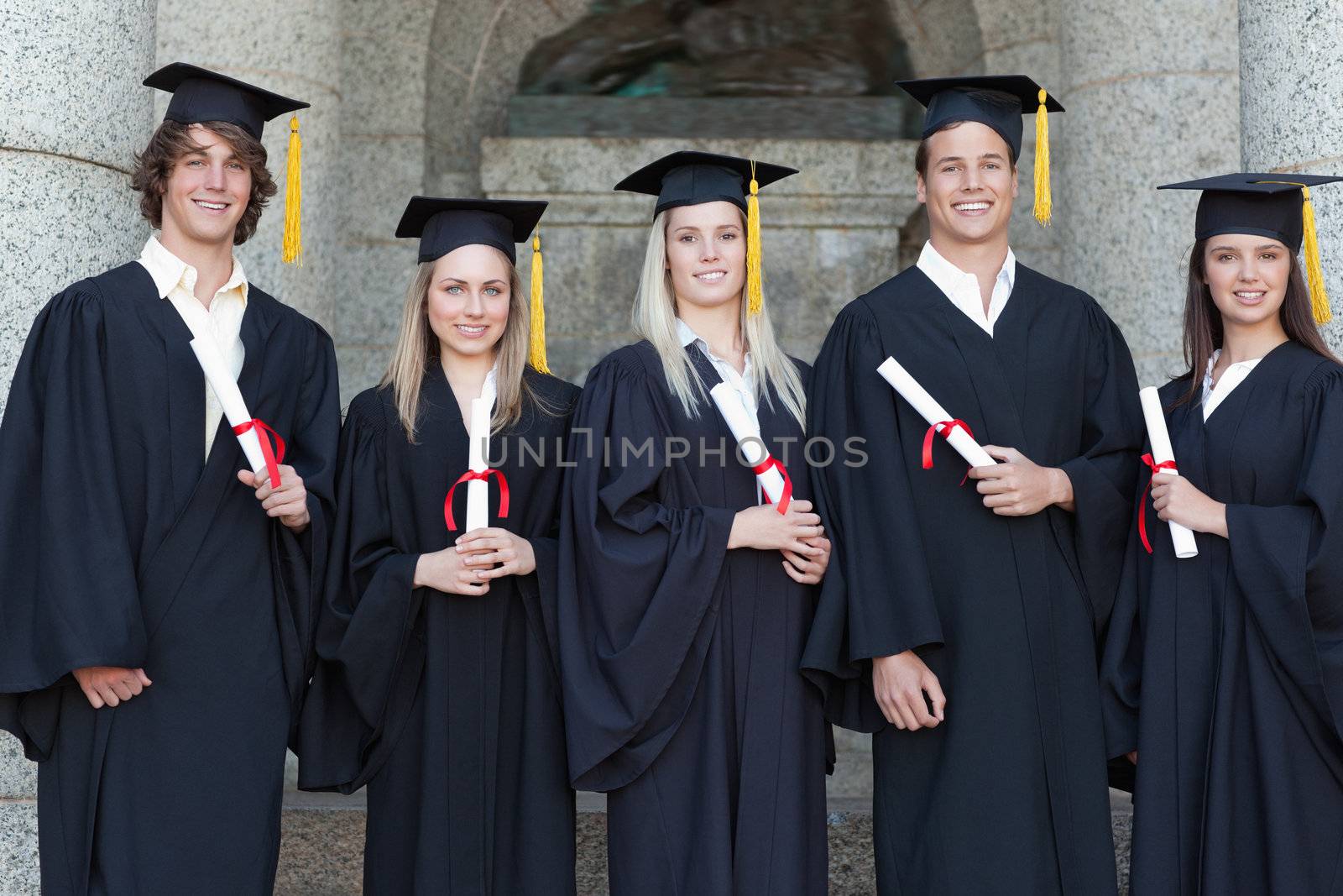Smiling graduates posing by Wavebreakmedia