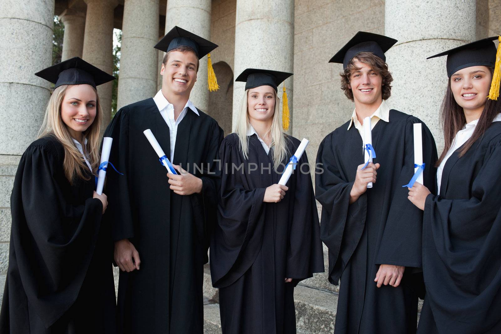 Graduates together in front of their university