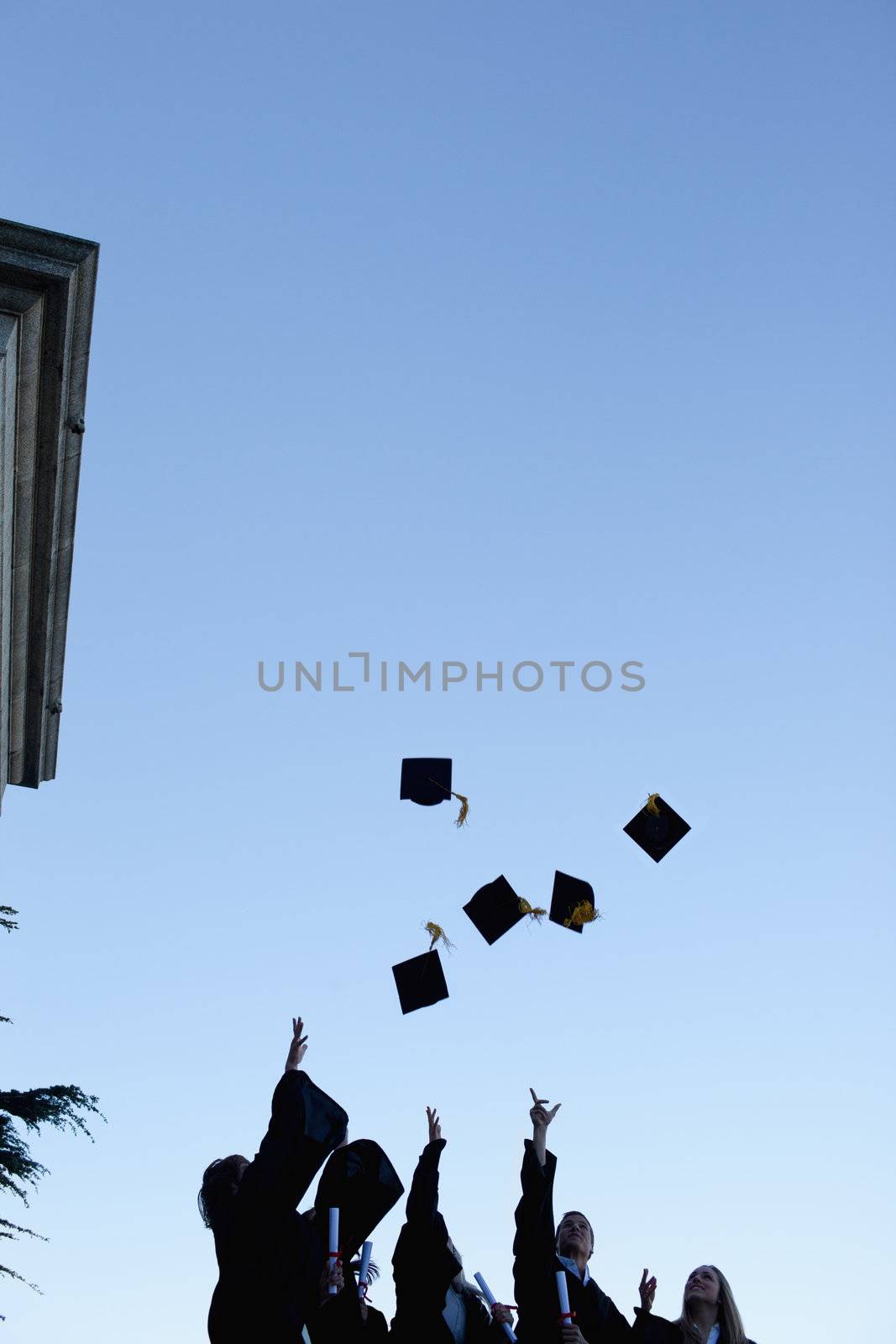 Five grad students throwing their hats in the sky  by Wavebreakmedia