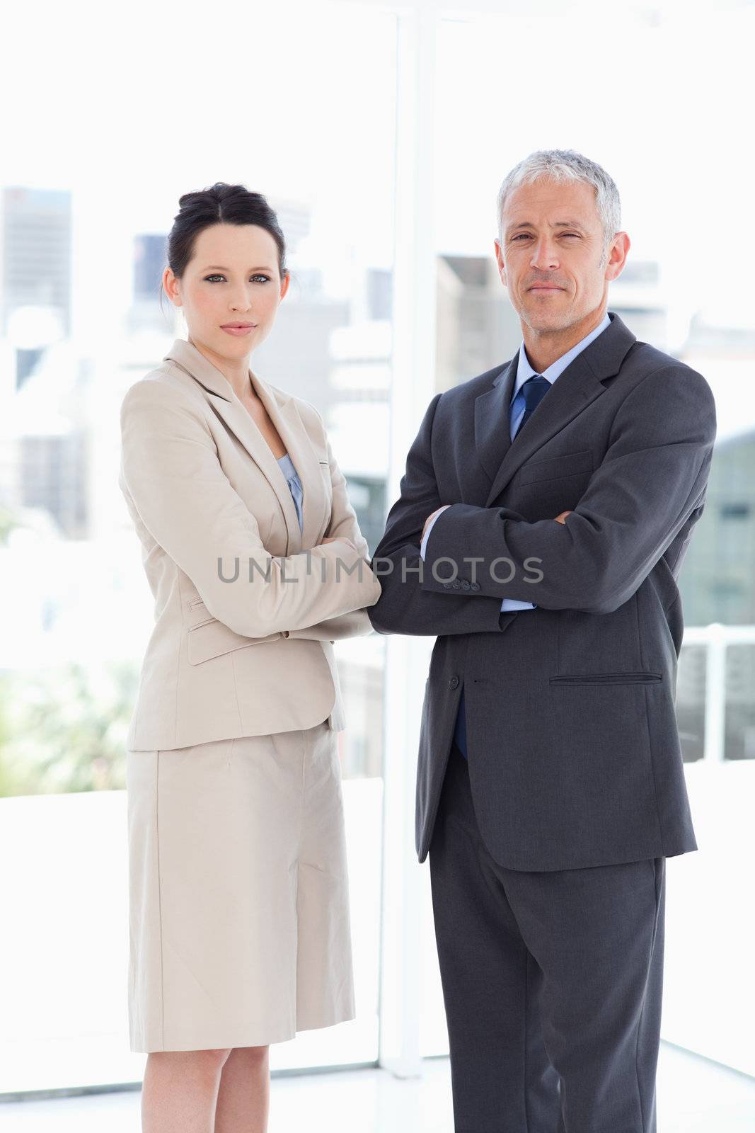 Young businesswoman standing upright in front of the window with her director