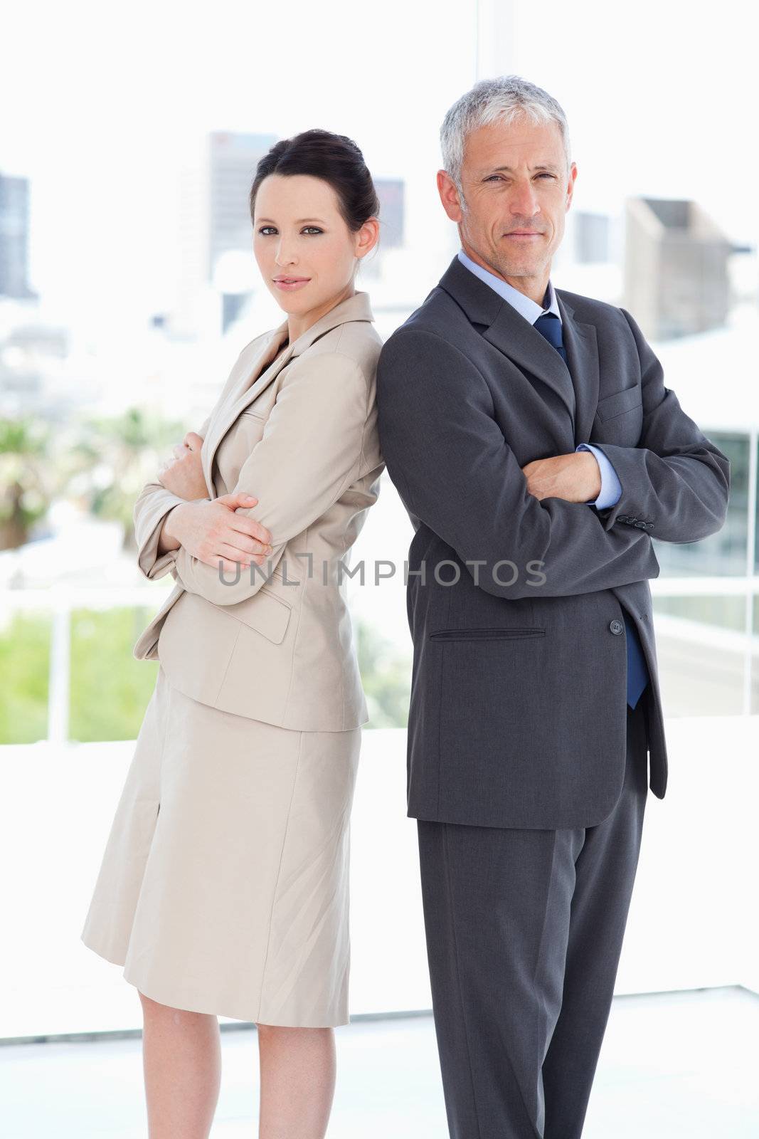 Two business people standing seriously in a well-lit room