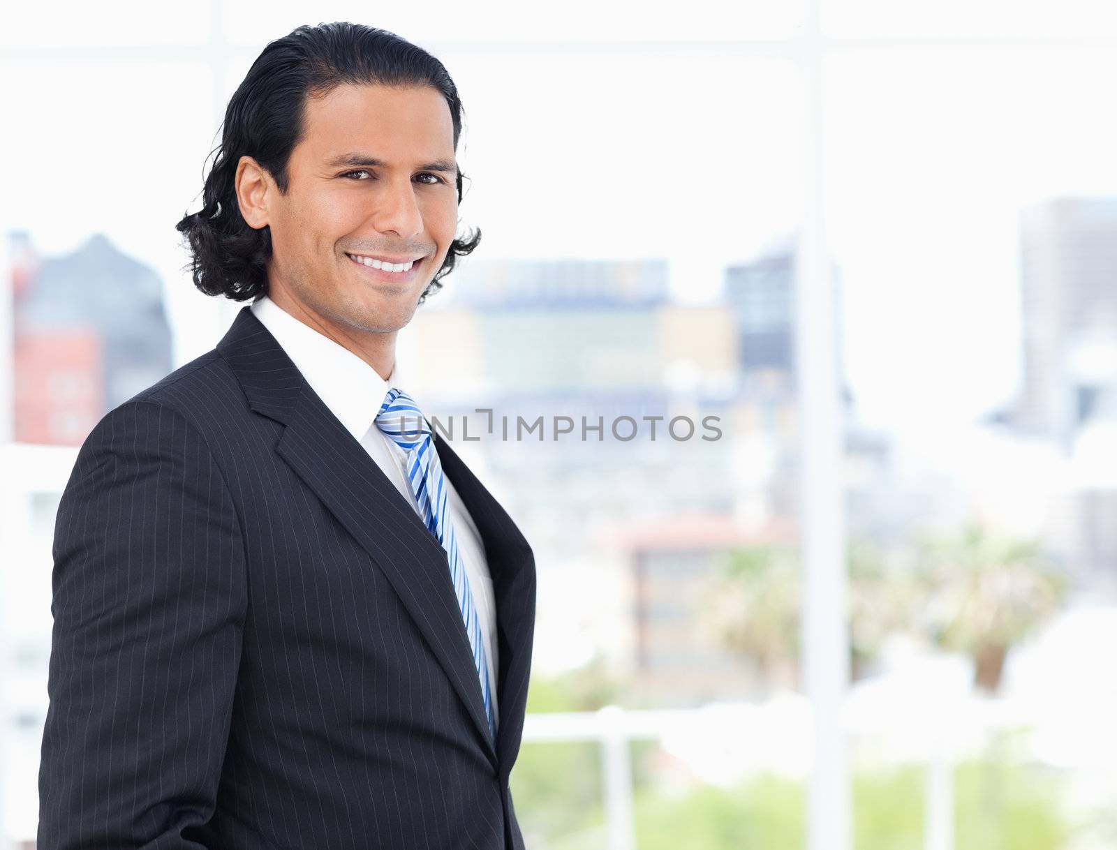 Executive proudly standing in front of a window