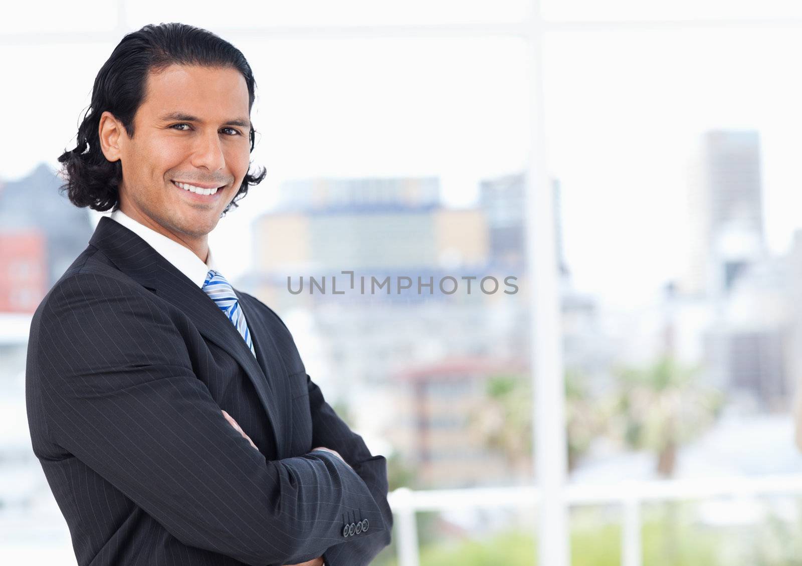 Young executive standing upright in front of a window and proudly looking towards the side