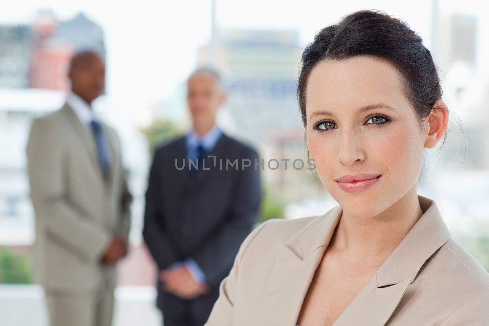 Young smiling secretary standing in front of two businessmen in a relaxed way
