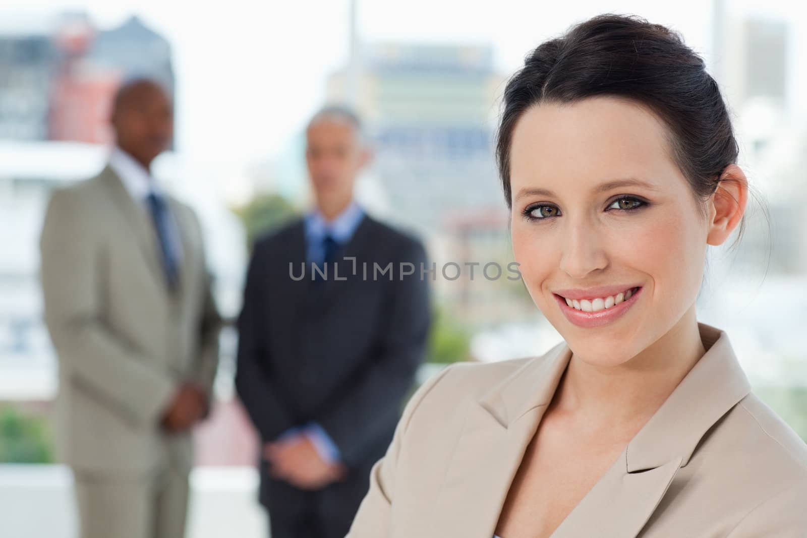 Young secretary standing upright in a relaxed way and showing a beaming smile