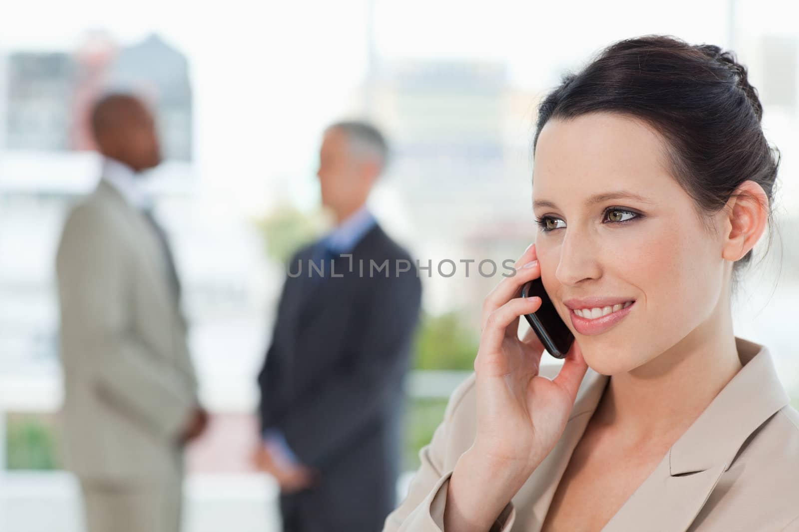Smiling secretary talking on the phone while looking towards the side