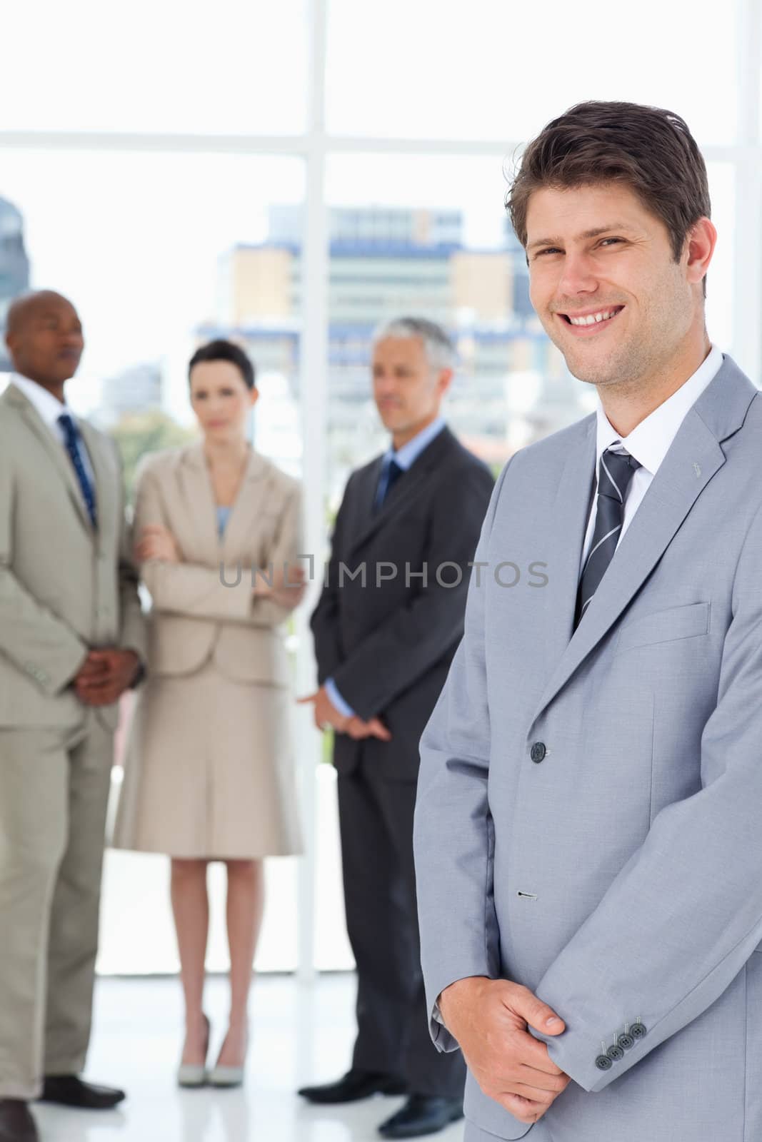 Business team looking at the smiling executive in front of them