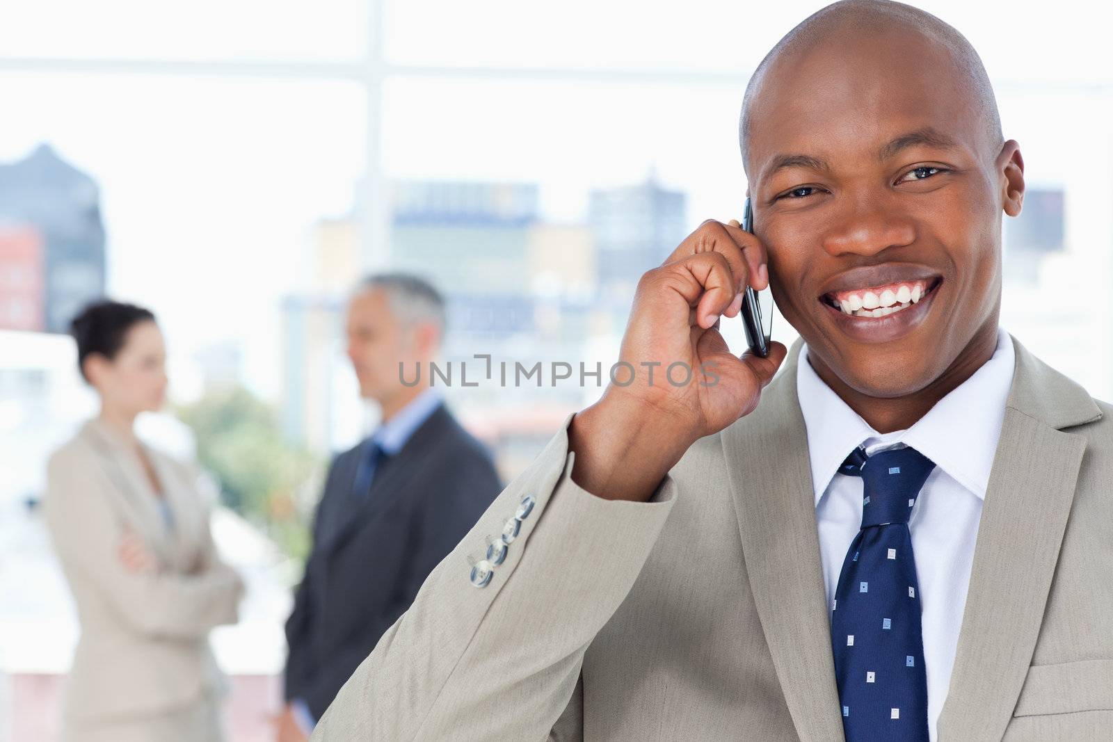 Young executive laughing while using his mobile phone