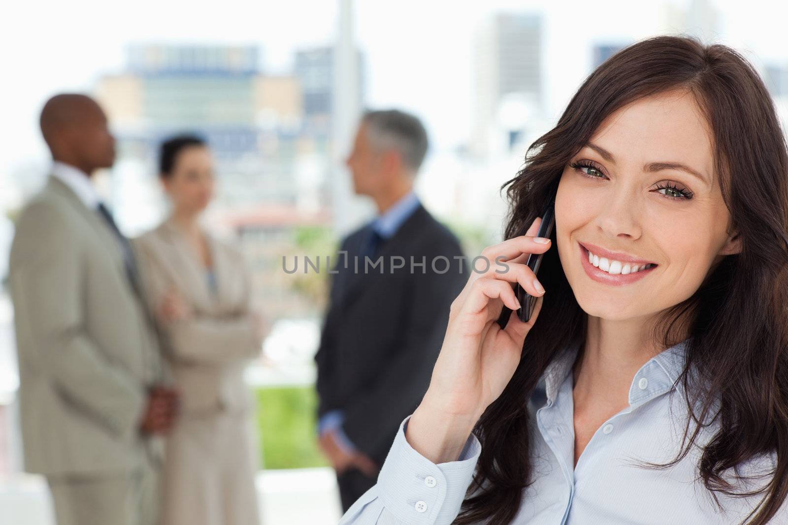 Young smiling executive woman on the cell phone and tilting her head to one side