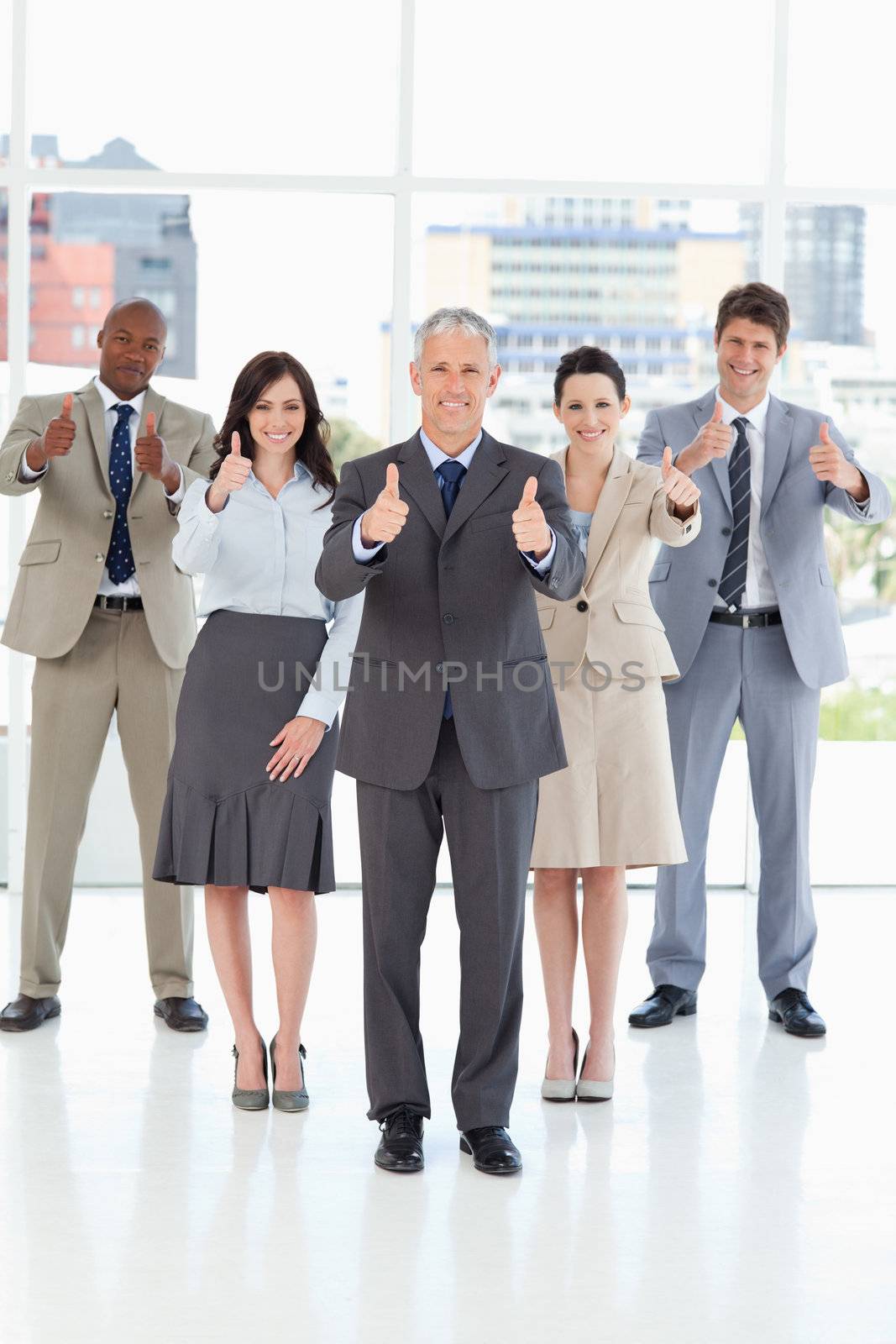 Business team standing together with their thumbs up in success by Wavebreakmedia