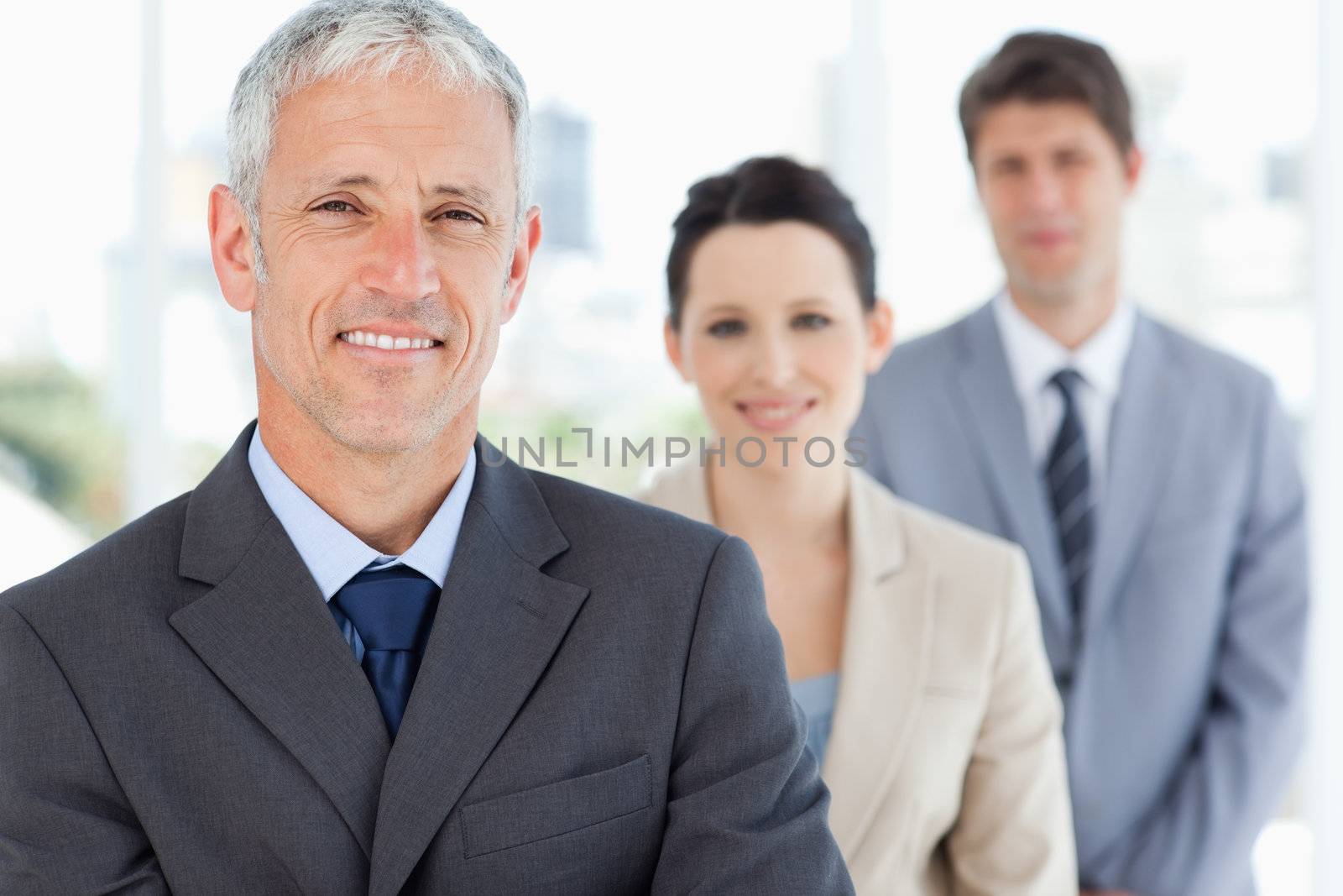 Mature manager followed by two young business people by Wavebreakmedia