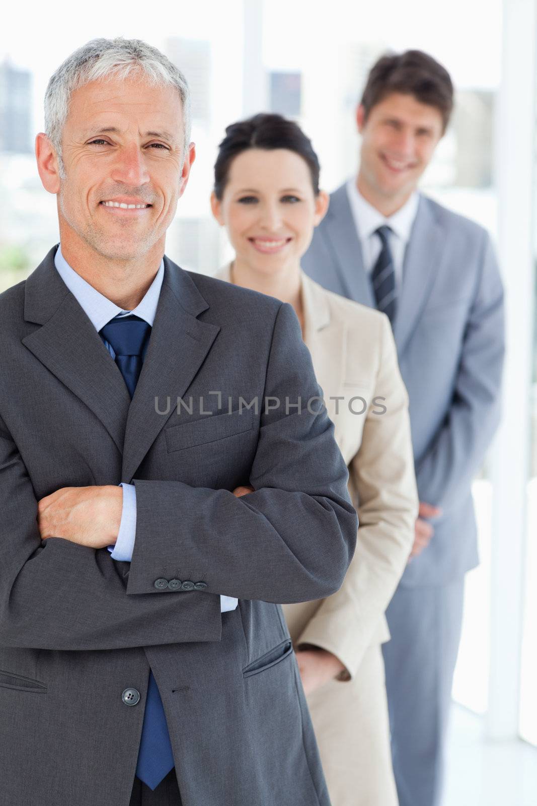 Smiling mature businessman standing upright in front of his youn by Wavebreakmedia