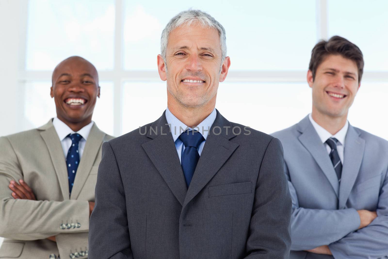 Two young employees standing in the back while laughing and bein by Wavebreakmedia