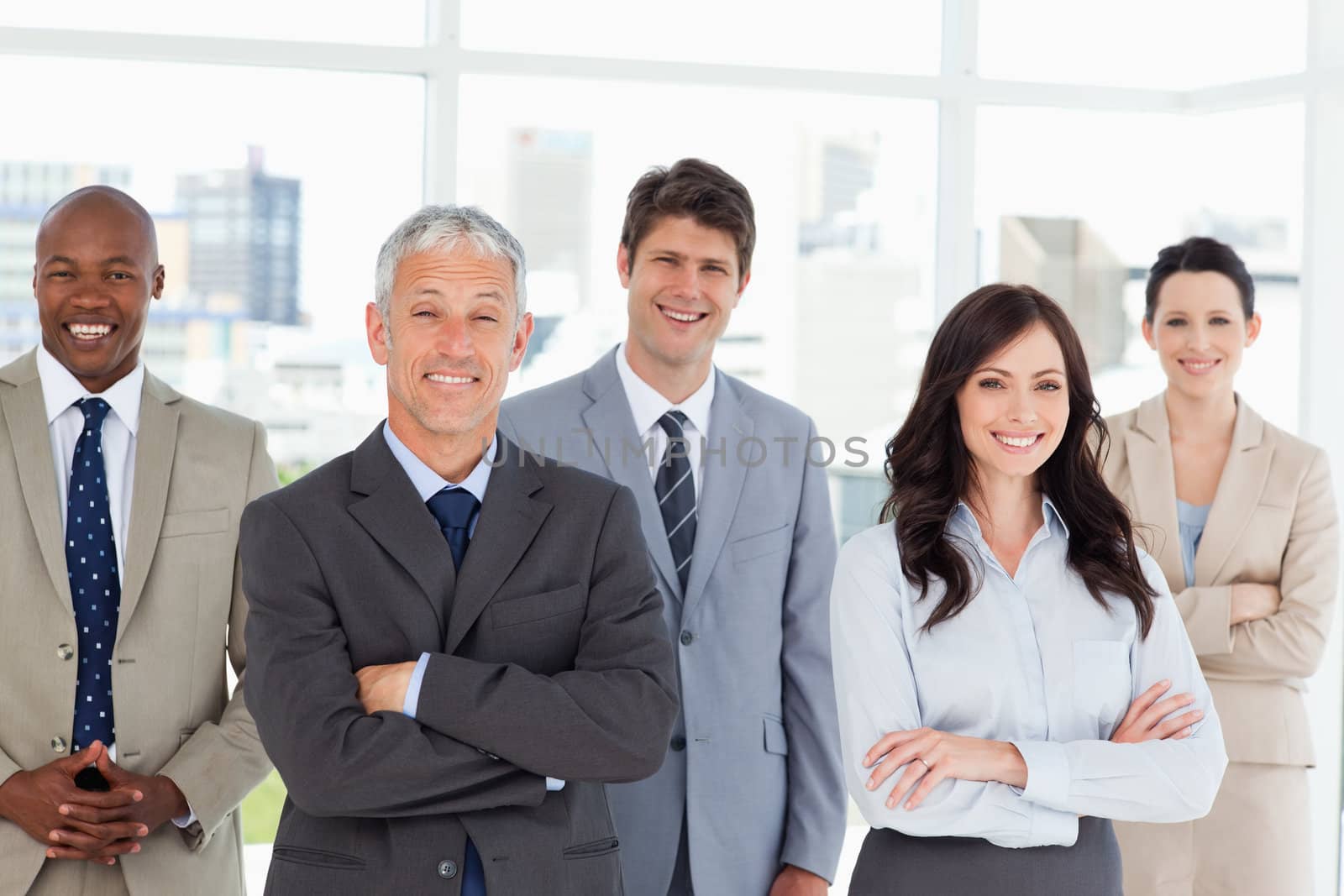 Five business people crossing their arms in front of a bright wi by Wavebreakmedia