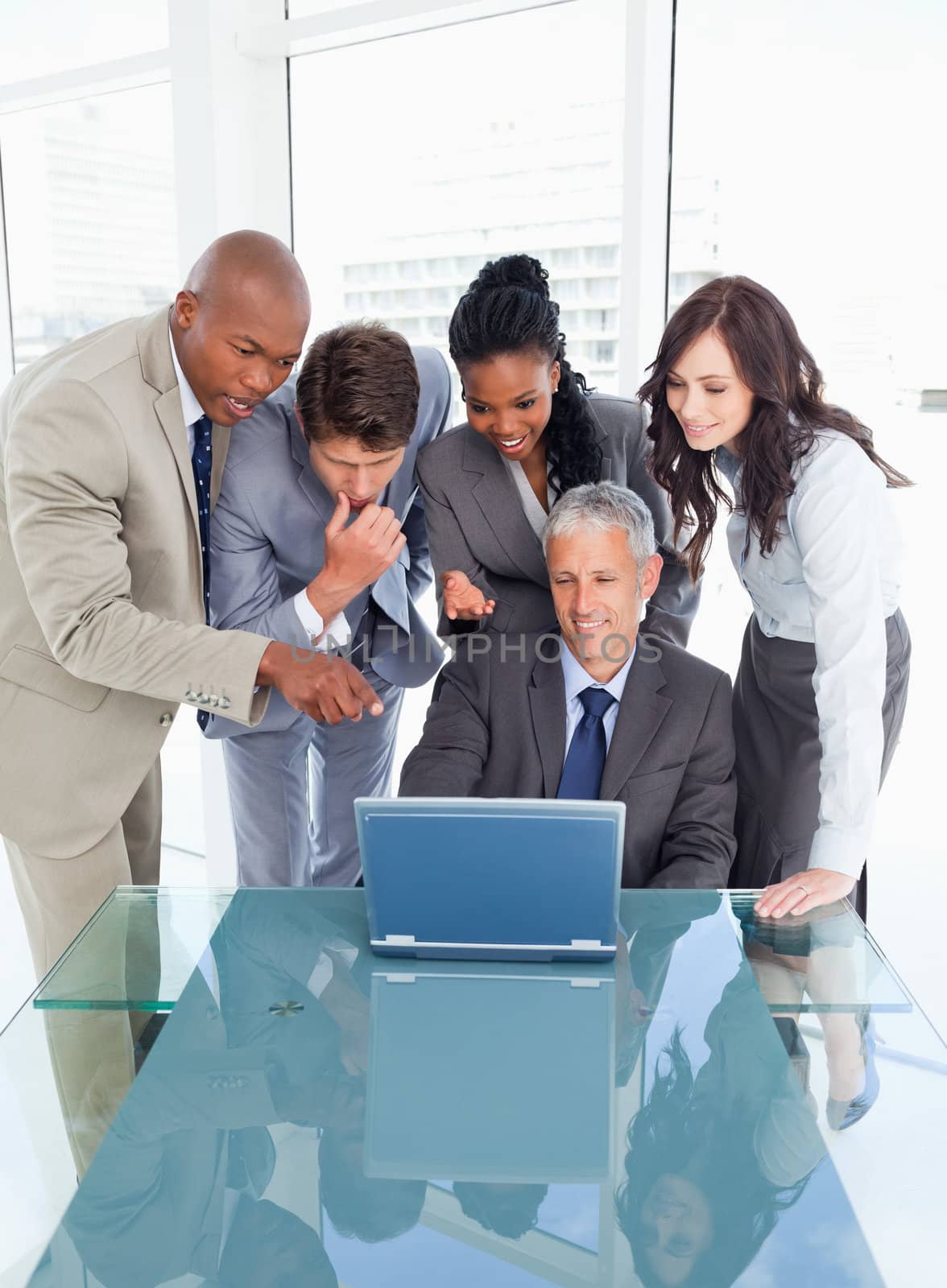 Young smiling executives attentively looking at the laptop screen