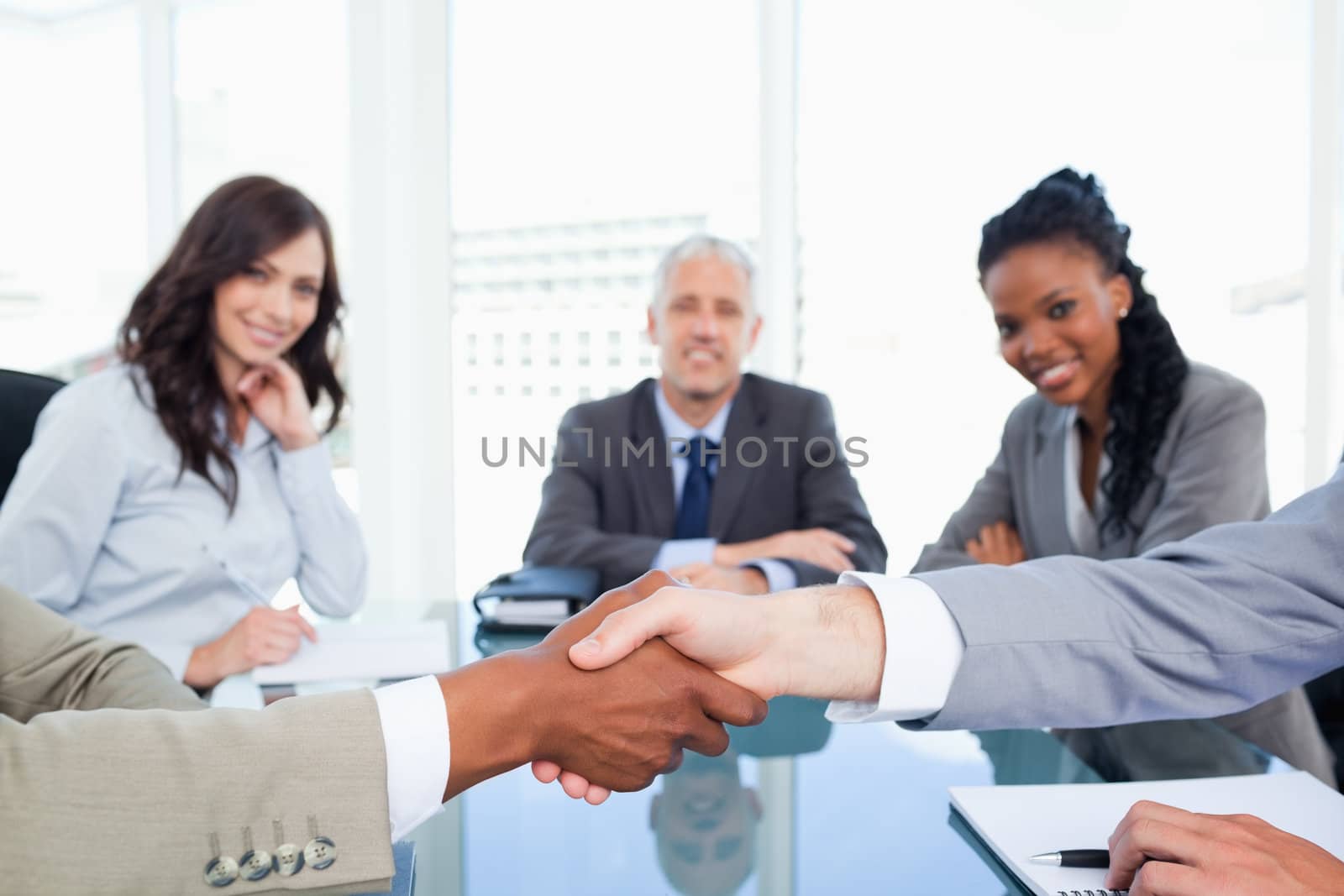 Two executives shaking hands during a meeting by Wavebreakmedia