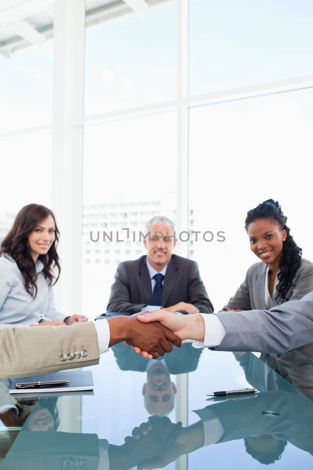 Handshake between two employees during a meeting by Wavebreakmedia