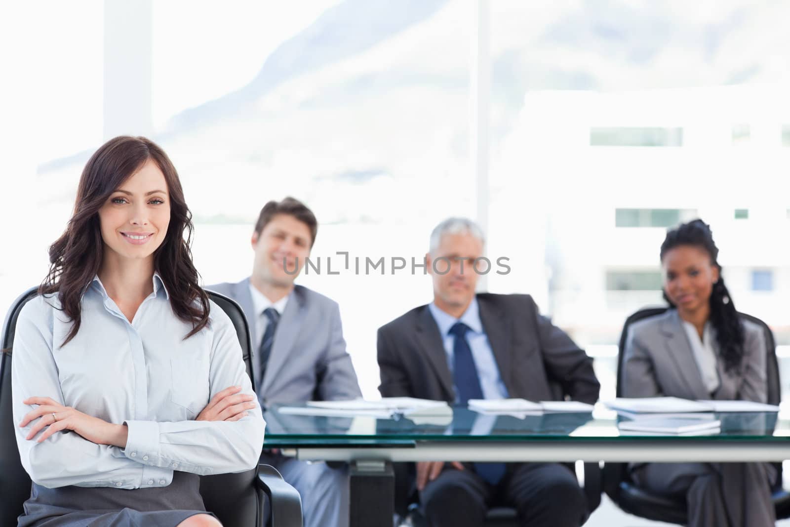 Smiling young businesswoman crossing her arms while accompanied  by Wavebreakmedia