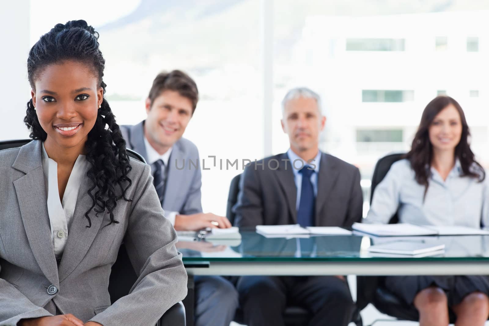Smiling serious businesswoman sitting in front of her team