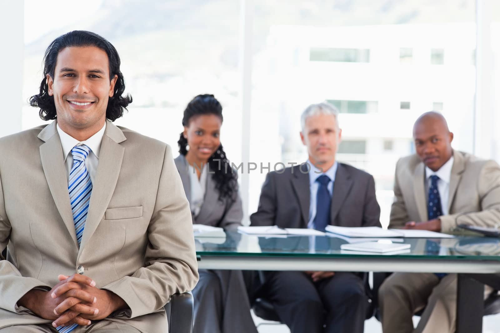 Executive smiling while sitting with her hands crossed on her leg