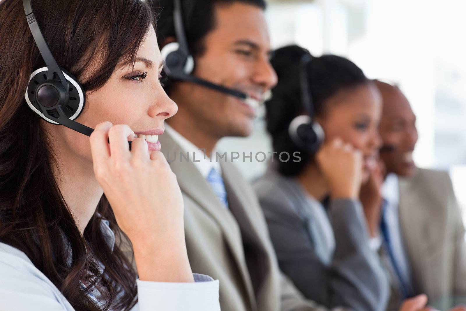 Young businesswoman working with a headset and accompanied by he by Wavebreakmedia