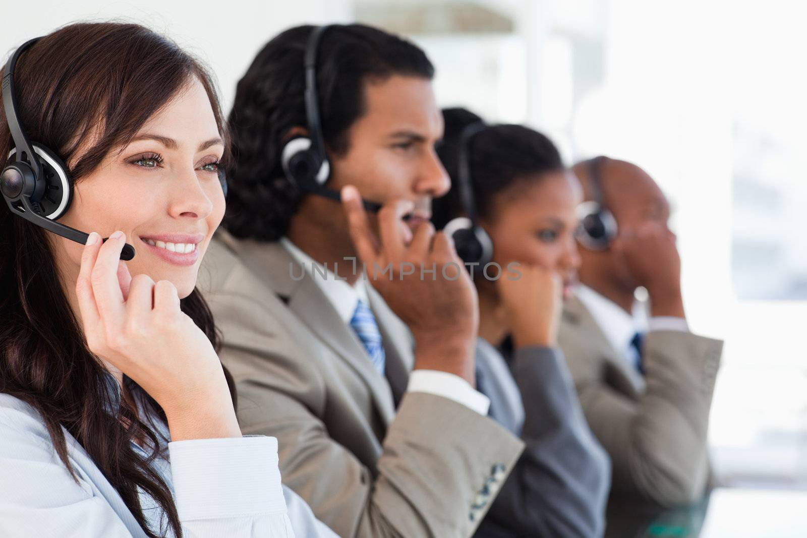 Smiling call centre employee working while accompanied by her te by Wavebreakmedia