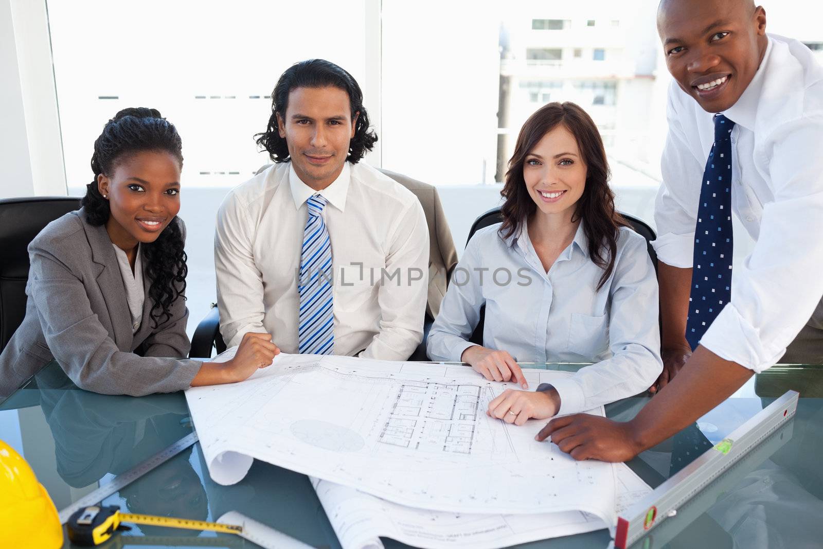 Business team smiling while working on a project in a bright meeting room