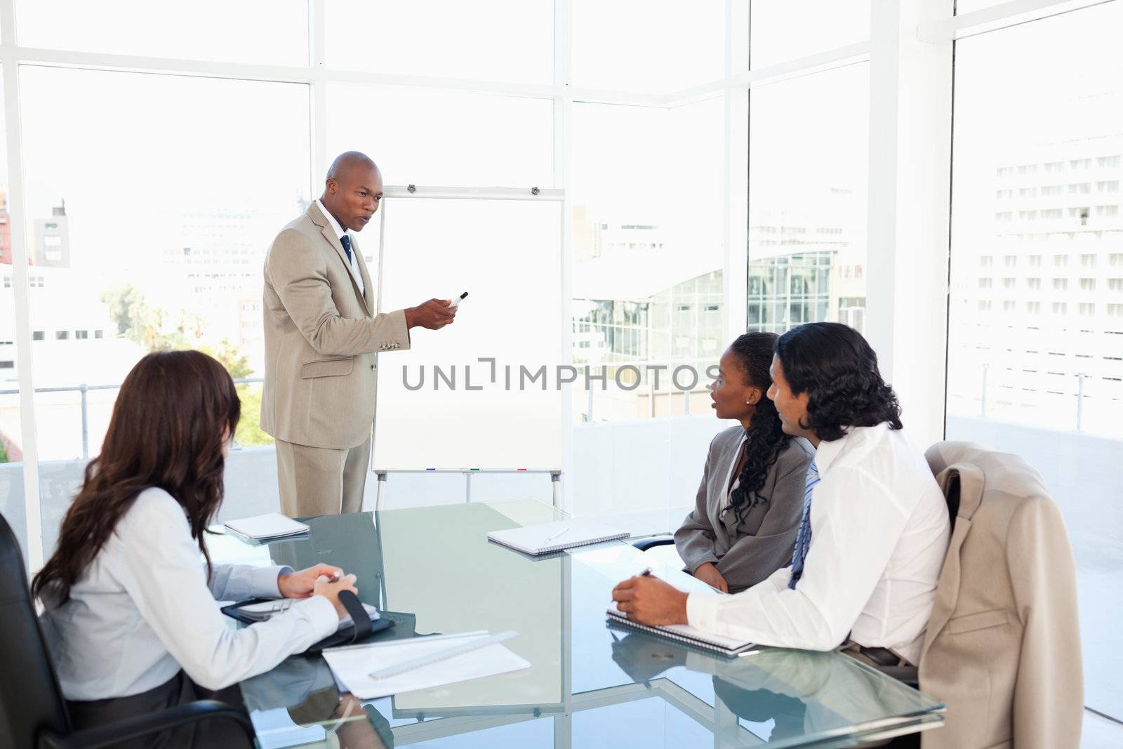 Businessman pointing to something on the flipchart to explain th by Wavebreakmedia