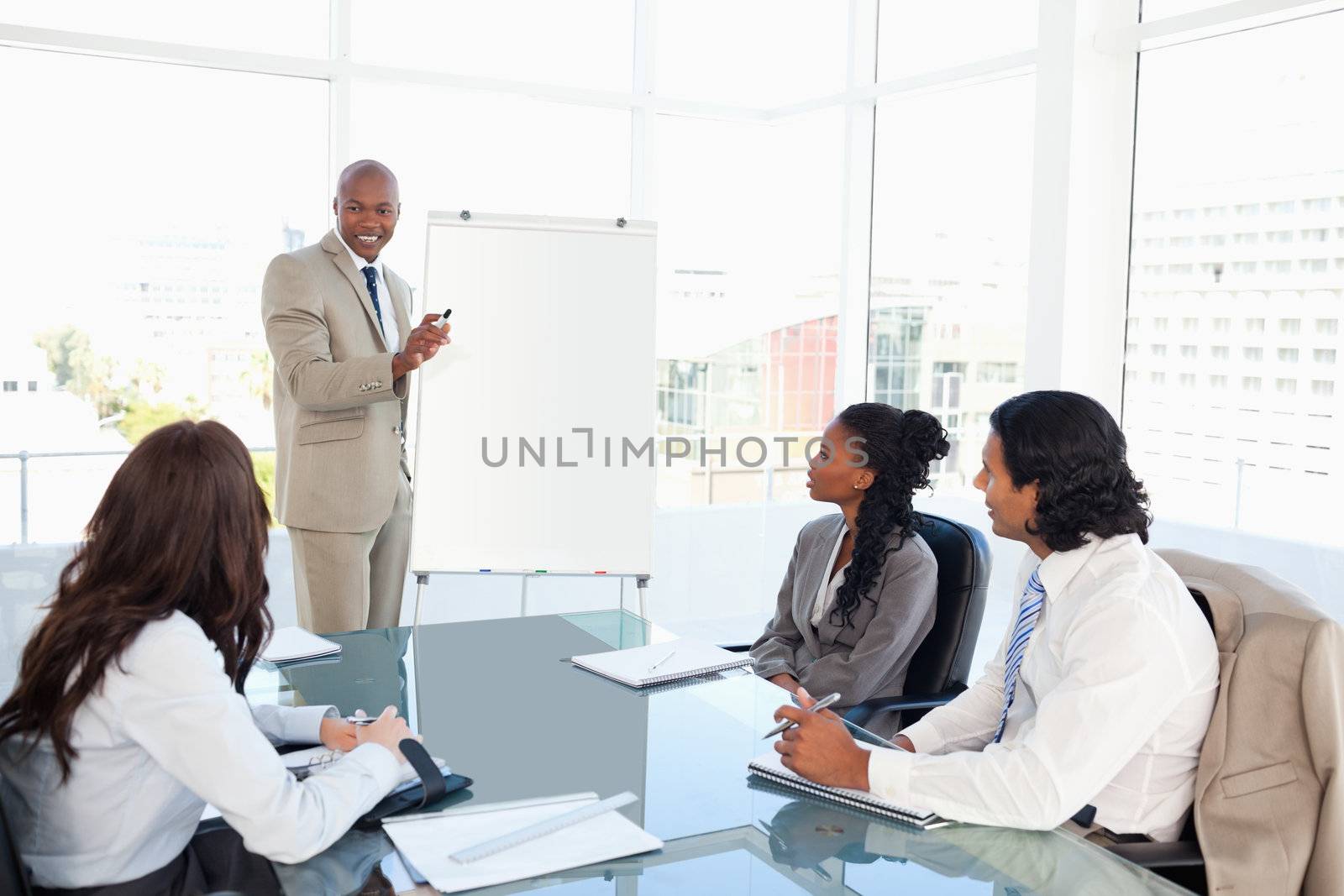 Businessman giving a presentation in front of his colleagues by Wavebreakmedia