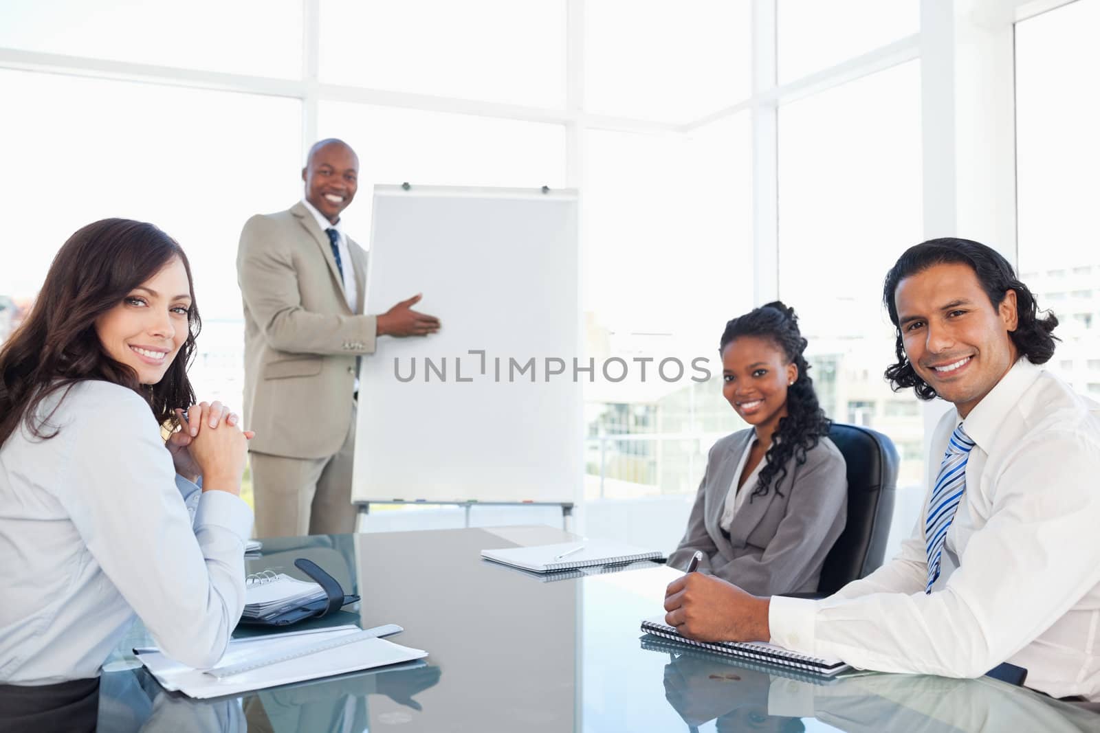 Smiling executive showing a flipchart with his relaxed colleagues