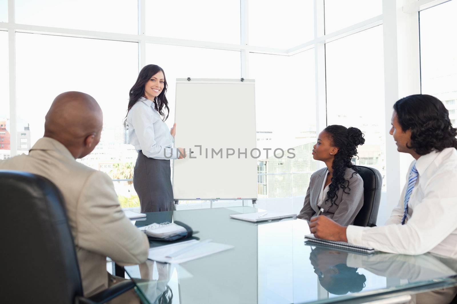 Businesswoman giving a presentation while her co-workers are lis by Wavebreakmedia